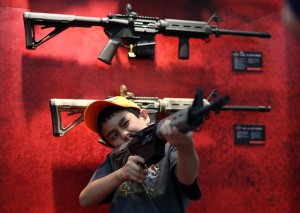 HOUSTON, TX - MAY 04:  An young attendee inspects an assault rifle during the 2013 NRA Annual Meeting and Exhibits at the George R. Brown Convention Center on May 4, 2013 in Houston, Texas.  More than 70,000 peope are expected to attend the NRA's 3-day annual meeting that features nearly 550 exhibitors, gun trade show and a political rally. The show runs from May 3-5.  (Photo by Justin Sullivan/Getty Images)