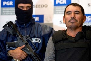 Santiago Meza Lopez, a.k.a. "El Pozolero" (R) is escorted by members of the Federal Police in Mexico City, on January 25, 2009. Meza Lopez, was deteined the last 23 January at the Tijuana munnicipality, Meza is the number 20th on the FBI most wanted list, allegedly helped a drug cartel dispose of around three hundred of victims by dissolving them in acid. AFP PHOTO/Alfredo ESTRELLA